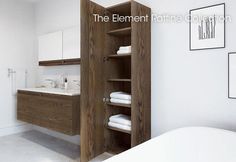 a bathroom with white towels and wooden cabinet in the corner, next to a bathtub