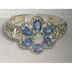 a white gold ring with blue and white stones on it's center flower design