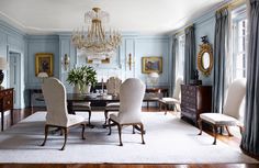 an elegant dining room with blue walls and chandelier