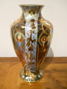 a large vase sitting on top of a wooden table next to a white wall and floor