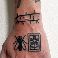 a person's hand with tattoos on it and an insect drawn on the wrist