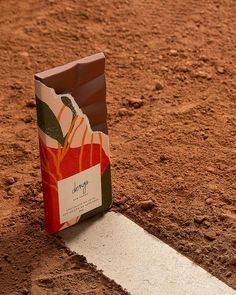 a chocolate bag sitting on top of a dirt field