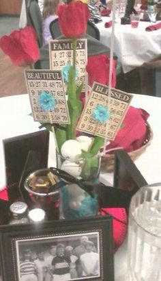 a vase filled with flowers sitting on top of a table next to pictures and candles