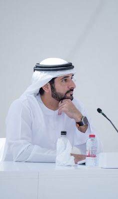 a man sitting at a table in front of a microphone