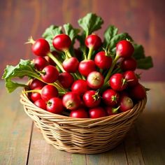 a basket filled with lots of red berries on top of a wooden table next to green leaves