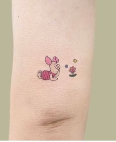 a small tattoo on the leg of a woman's thigh with a cartoon character