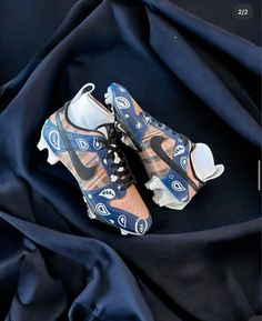 a pair of sneakers sitting on top of a blue cloth covered in black and white fabric