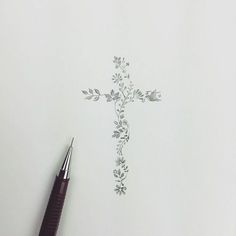 a pen sitting on top of a piece of paper with a cross drawn on it