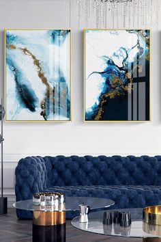 three paintings hang on the wall above a blue velvet couch in an elegant living room