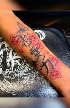 a woman's arm with flowers and an anchor tattoo on the left side of her arm