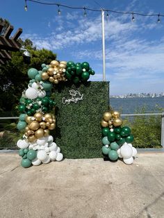 a green and gold balloon arch on the ground