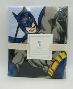 batman wrapping paper in blue and yellow with white ribbon on the bottom, featuring an image of