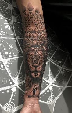 a man's arm with a lion tattoo on it and a person holding his hand up