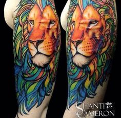 a colorful tattoo with a lion on it's arm and the head of a lion