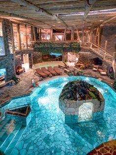 an indoor swimming pool surrounded by stone walls