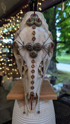 an animal skull with various jewels on it's head sitting on top of a table