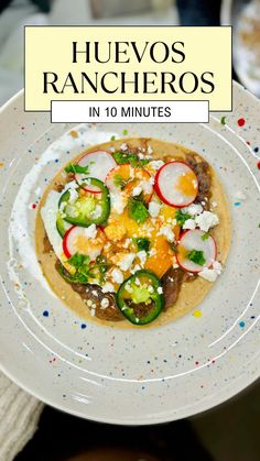 a white plate topped with an egg and vegetable tostada on top of a table