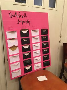 a pink and black bulletin board sitting on top of a wooden table next to a brown chair