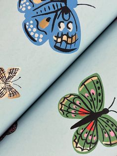 two butterflies on blue fabric with white dots and black spots, one has a skull in the middle