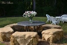 hay bales stacked on top of each other in front of a table and chairs