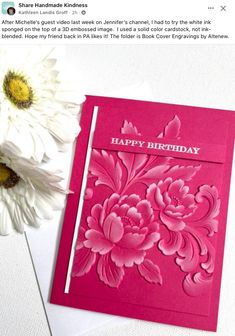 a pink and white flower next to a card with the words happy birthday on it