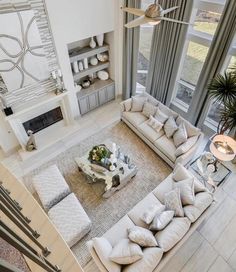 an aerial view of a living room with couches, coffee table and large windows