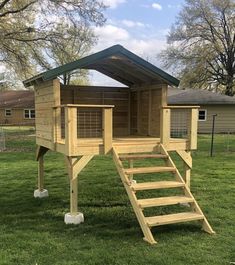 a small wooden structure with steps leading up to the top and bottom floor, in grass