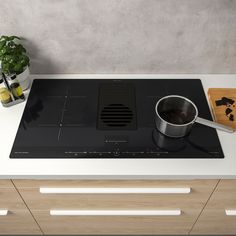 a stove top with a pot on the burner and a cutting board next to it