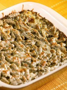 a casserole dish with meat and cheese in it on a yellow tablecloth