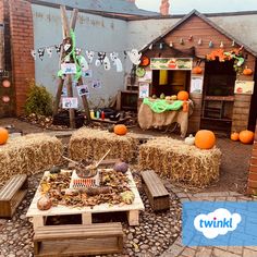 pumpkins and hay bales are arranged in front of a building with decorations on it