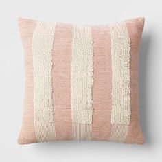 a pink and white striped pillow on a wall