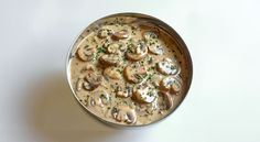 a bowl filled with mushroom soup on top of a white table