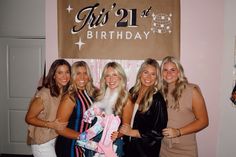 four beautiful women standing next to each other in front of a birthday banner