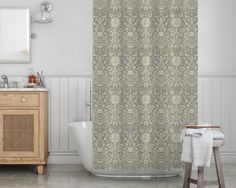 a bathroom with a sink, toilet and shower curtain that has an ornate pattern on it