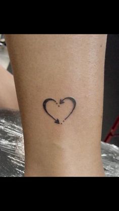 a small heart with an arrow tattoo on the side of her leg, is shown