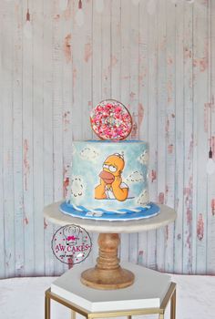 the simpsons cake is decorated with sprinkles and donuts on it's top