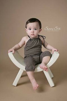 a baby is sitting on a white chair