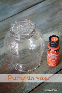 there is a glass jar with an orange liquid next to it on the wooden table