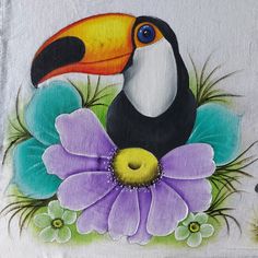 a toucan sitting on top of a purple flower