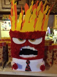 a red and yellow costume with flames on it's head is sitting on a table