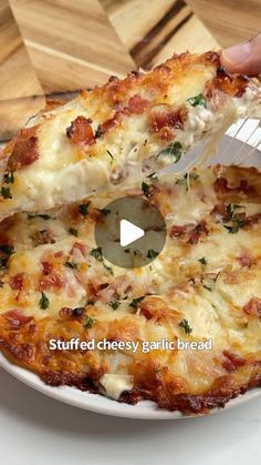 someone cutting into a cheesy garlic bread pizza