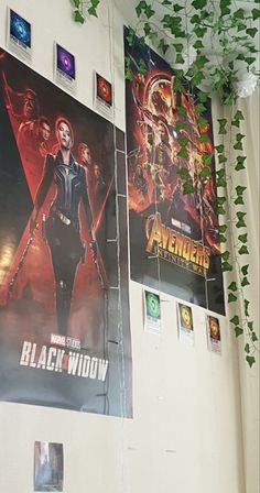 the avengers movie poster is hanging up on the wall next to some posters and plants