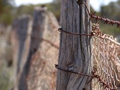 an old wooden fence with barbed wire