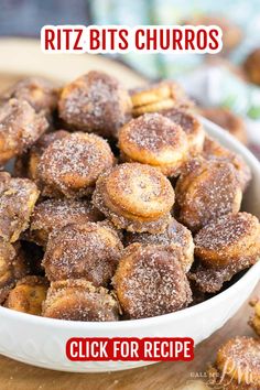 a white bowl filled with cinnamon rolls on top of a wooden table