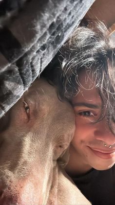 a woman and a dog are smiling for the camera with their noses close to each other