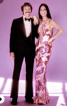 a man in a tuxedo standing next to a woman in a pink dress