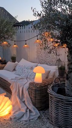 an outdoor seating area with wicker furniture and lights