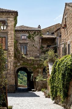 an old stone building with ivy growing on it's walls and doorway leading to another building