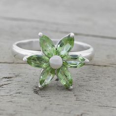 A sparkling daisy is realized with petals of green peridot, totaling over one carat altogether. Shanker presents this elegant cocktail ring, handcrafted with sterling silver by local Indian artisans. materials: 925 sterling silver, peridot High polish finish Natural stone - some variations in color and/or pattern are to be expected View size info Gold Wrap Ring, Moissanite Engagement Ring White Gold, Delicate Gold Ring, Leaf Engagement Ring, Amethyst Necklace Pendant, Peridot Jewelry, Gold Wrap, Gold Cocktail Ring, Floral Ring