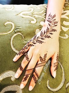 a woman's hand with henna tattoos on it